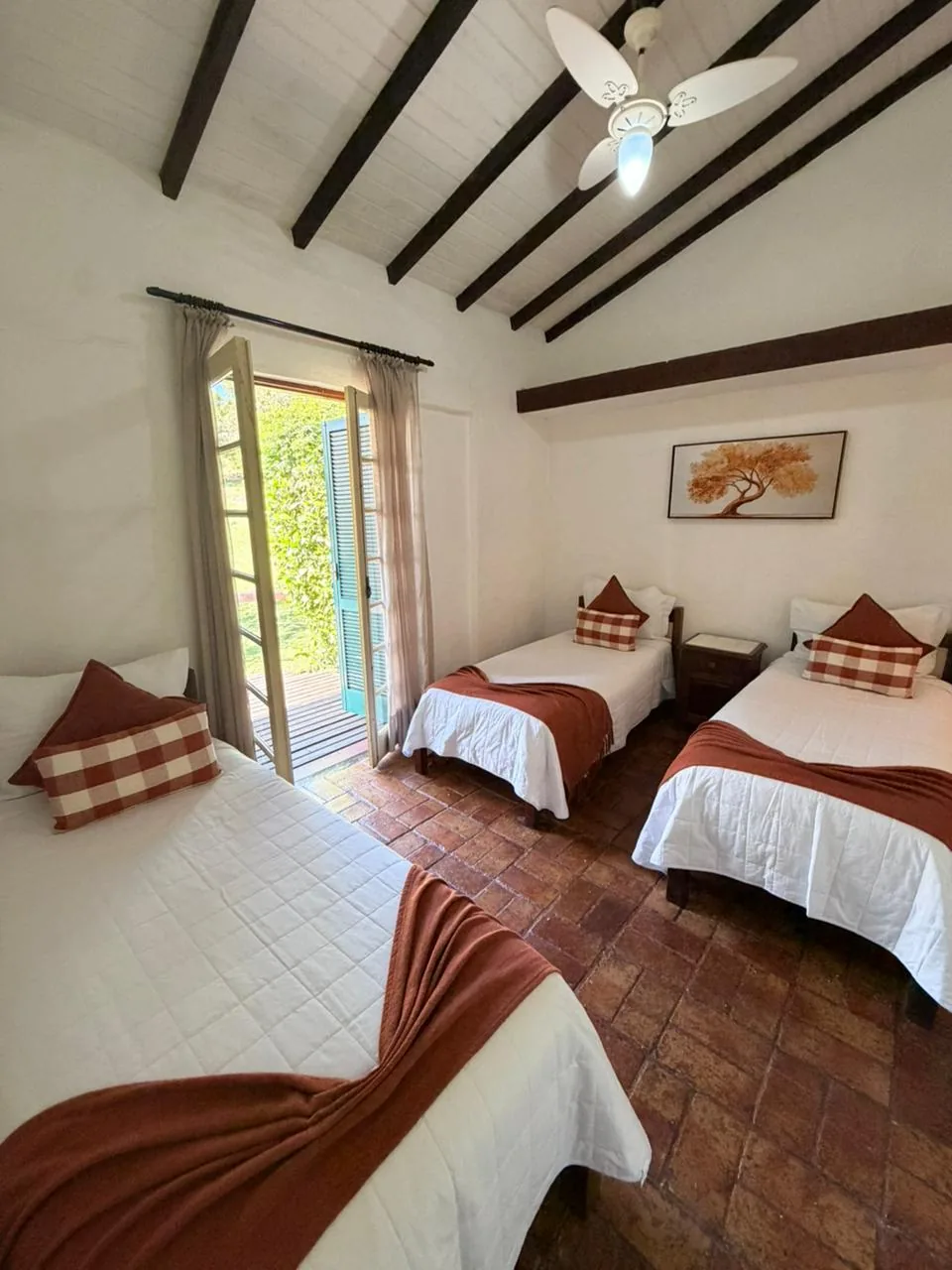 Quarto do Conjugado Master com cama de casal, camas de solteiro e porta aberta para o verde